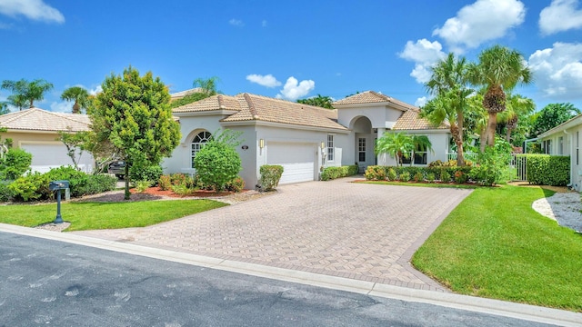 mediterranean / spanish-style home featuring a front yard and a garage