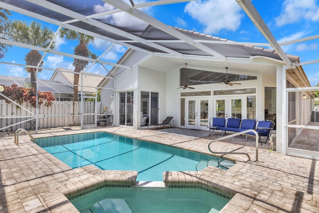 view of swimming pool featuring french doors, a patio area, glass enclosure, and ceiling fan