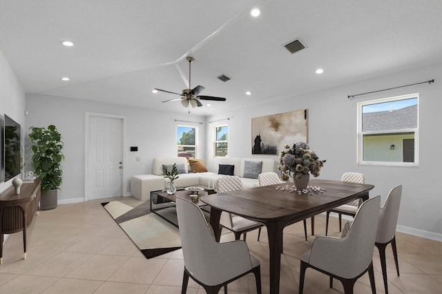 dining space with ceiling fan, light tile patterned floors, and vaulted ceiling