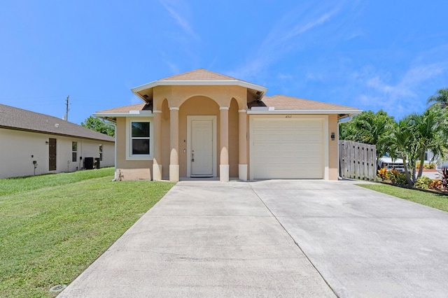 view of front of property with a garage, central air condition unit, and a front yard