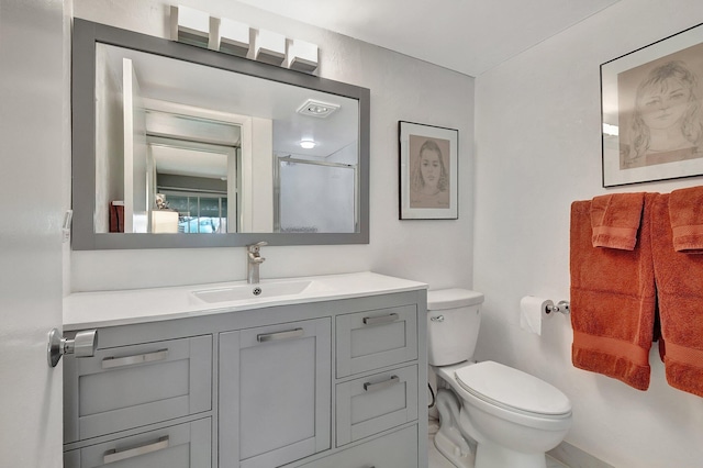 bathroom with a shower with door, vanity, and toilet