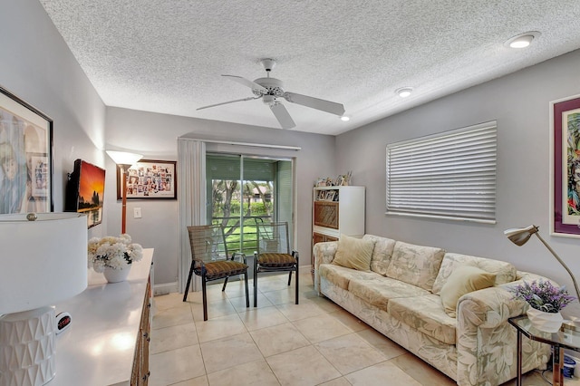 living room with a textured ceiling, light tile patterned floors, and ceiling fan