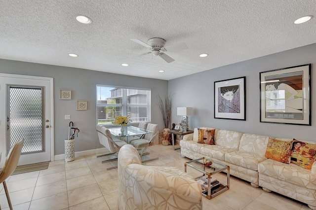 tiled living room with ceiling fan and a textured ceiling