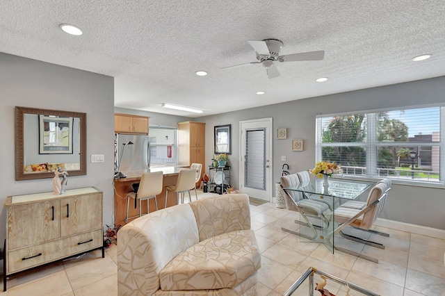 tiled living room featuring ceiling fan and a textured ceiling