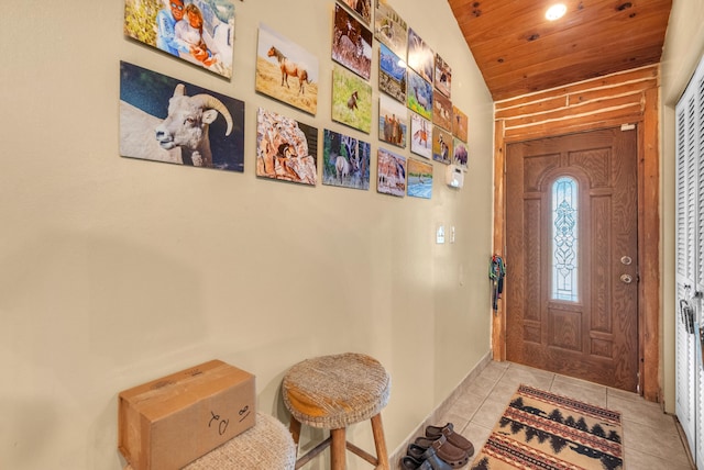 tiled foyer featuring wood ceiling and vaulted ceiling