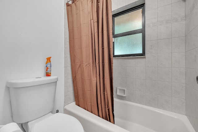 bathroom featuring shower / bath combo with shower curtain and toilet