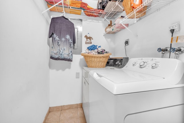 laundry area with light tile patterned floors and washer and clothes dryer