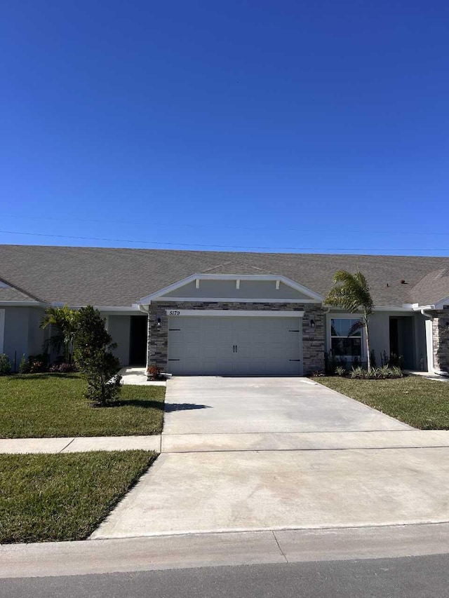 ranch-style home with a garage and a front lawn