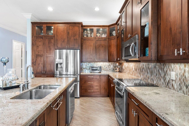 kitchen featuring crown molding, tasteful backsplash, light stone counters, sink, and appliances with stainless steel finishes