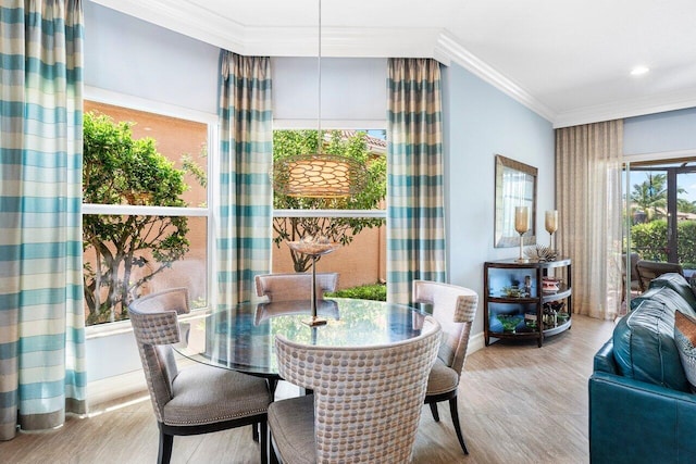 dining area featuring ornamental molding and light hardwood / wood-style floors