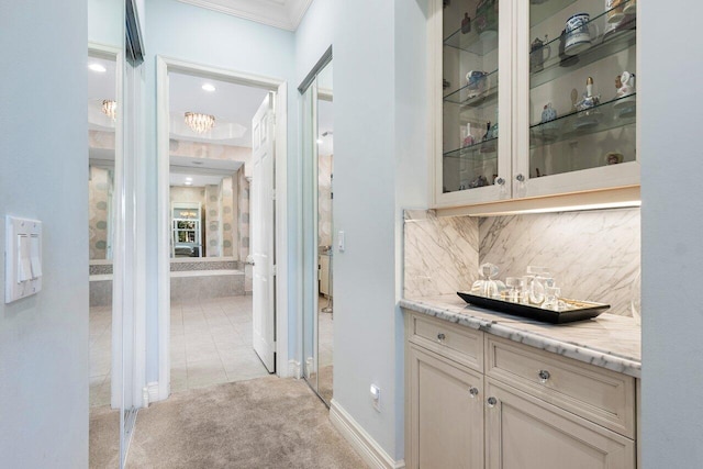 bar with crown molding, light stone countertops, light carpet, and tasteful backsplash