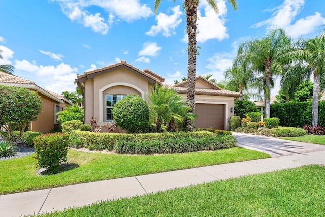 mediterranean / spanish house with a garage and a front lawn