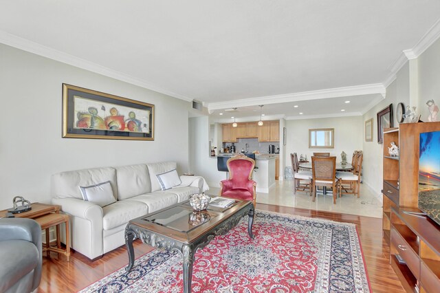 living room with ornamental molding and light hardwood / wood-style floors