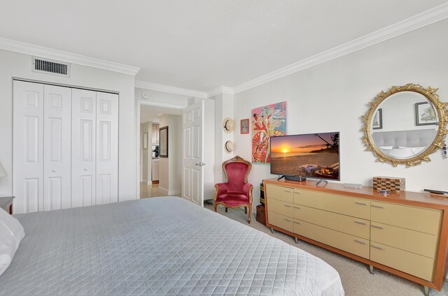 carpeted bedroom with crown molding and a closet