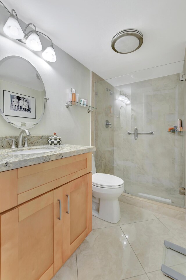 bathroom featuring vanity, toilet, walk in shower, and tile patterned floors