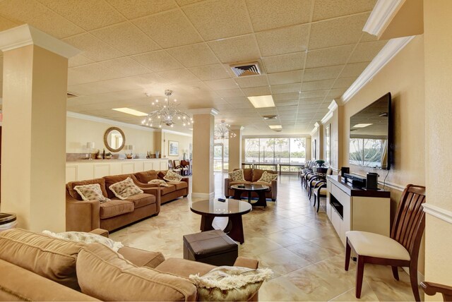 living room with crown molding, a paneled ceiling, light tile patterned floors, and a notable chandelier