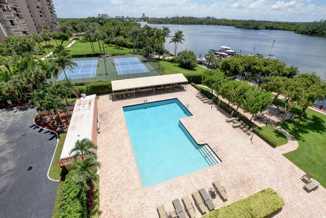 view of swimming pool with a water view and tennis court