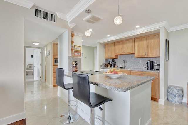 kitchen featuring crown molding, kitchen peninsula, pendant lighting, a kitchen bar, and decorative backsplash