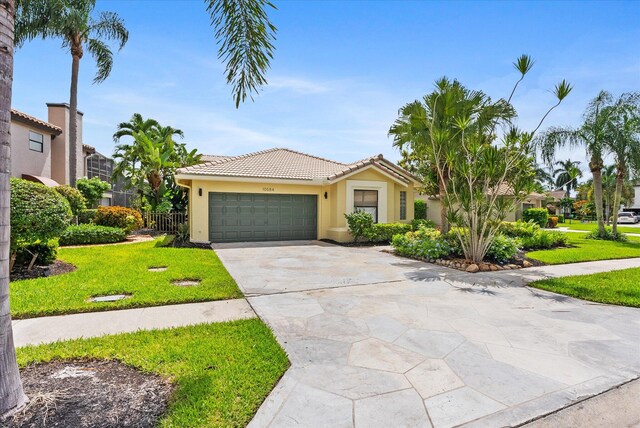 mediterranean / spanish house with a garage and a front lawn