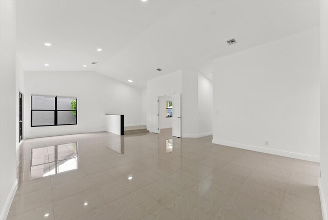 tiled empty room with vaulted ceiling