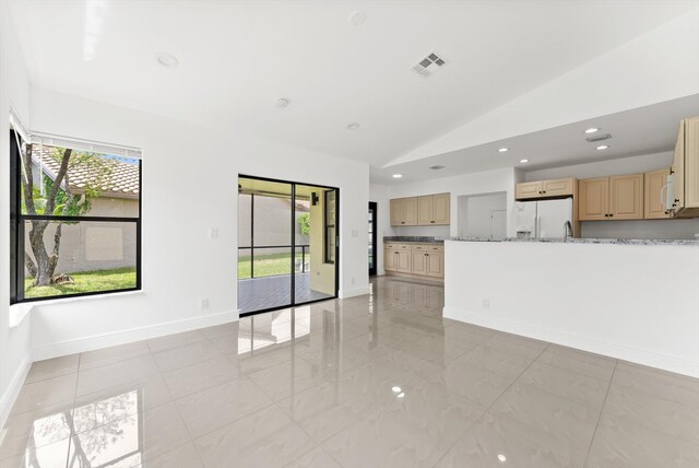 unfurnished living room featuring lofted ceiling