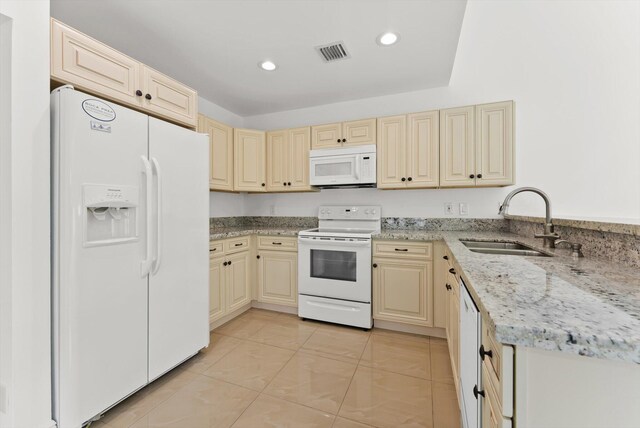 kitchen featuring white appliances, sink, and light stone countertops