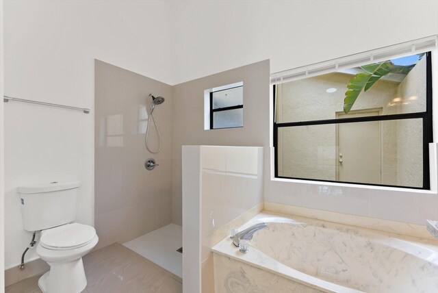 bathroom with toilet and shower with separate bathtub