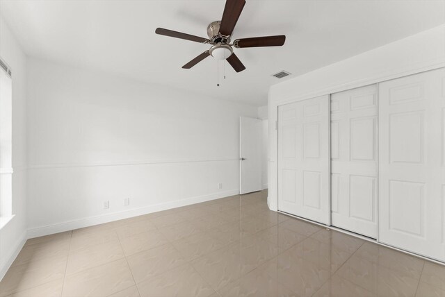 unfurnished bedroom featuring ceiling fan and a closet