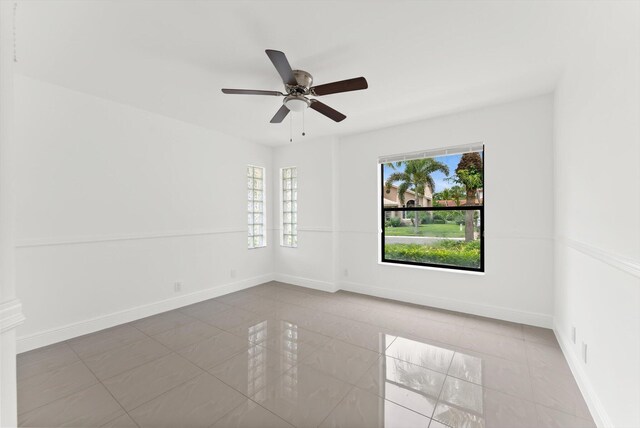 spare room with ceiling fan and light tile patterned flooring