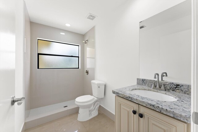 bathroom featuring vanity, toilet, a shower, and tile patterned floors