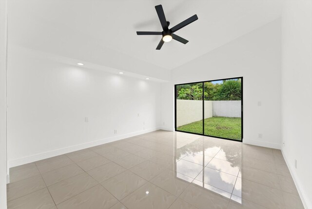 tiled empty room featuring high vaulted ceiling and ceiling fan