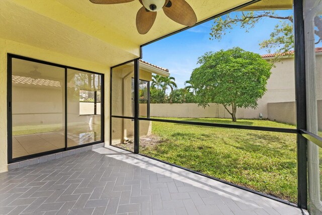 unfurnished sunroom with ceiling fan