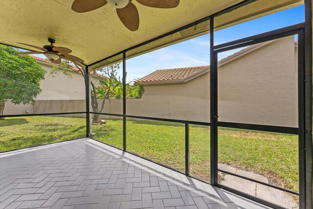 unfurnished sunroom featuring ceiling fan