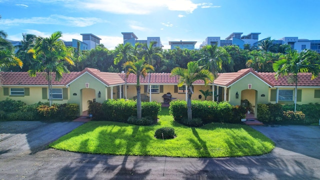 mediterranean / spanish home with a front lawn