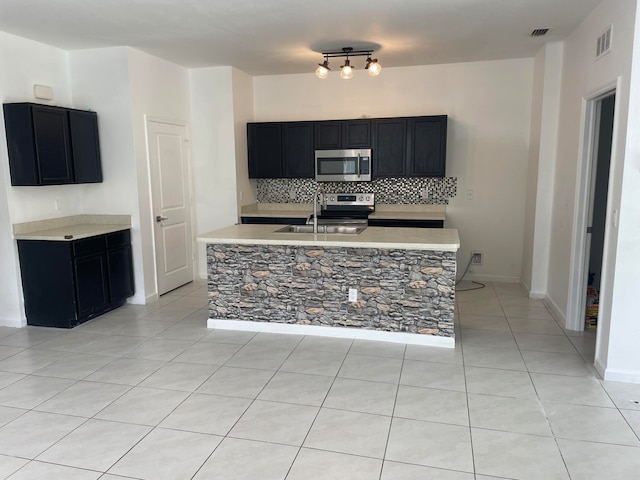 kitchen featuring stainless steel appliances, decorative backsplash, light tile patterned flooring, and sink