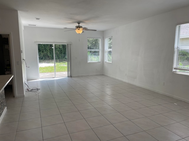 tiled empty room featuring ceiling fan