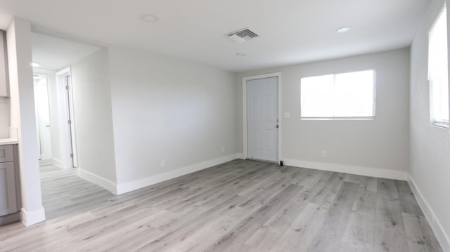 interior space featuring light wood-type flooring, gray cabinets, and stainless steel refrigerator with ice dispenser