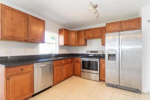 kitchen with stainless steel appliances, sink, and light tile patterned floors