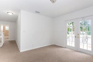 carpeted spare room with french doors