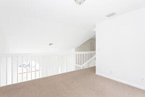 bonus room with vaulted ceiling and carpet floors