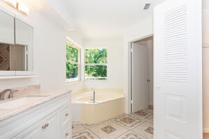 bathroom featuring a tub to relax in, vanity, and tile patterned flooring