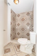 bathroom with tile walls and toilet