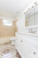 full bathroom with toilet, tiled shower / bath combo, and vanity