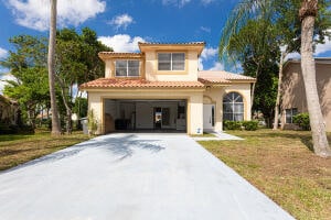 mediterranean / spanish-style house with a garage and a front lawn