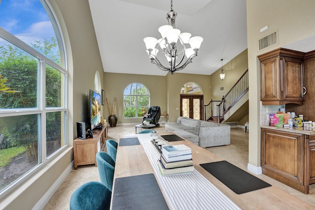 living room with high vaulted ceiling, plenty of natural light, and a chandelier