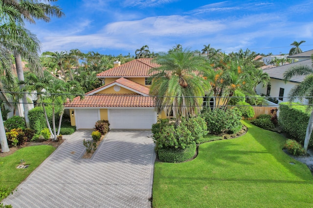 mediterranean / spanish-style home featuring a front yard and a garage