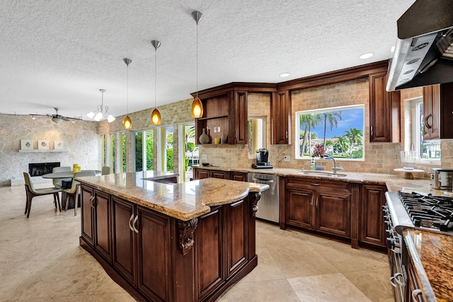 kitchen with a textured ceiling, stainless steel appliances, sink, and light stone countertops