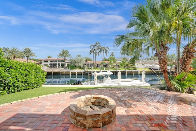 exterior space featuring an outdoor fire pit and a water view