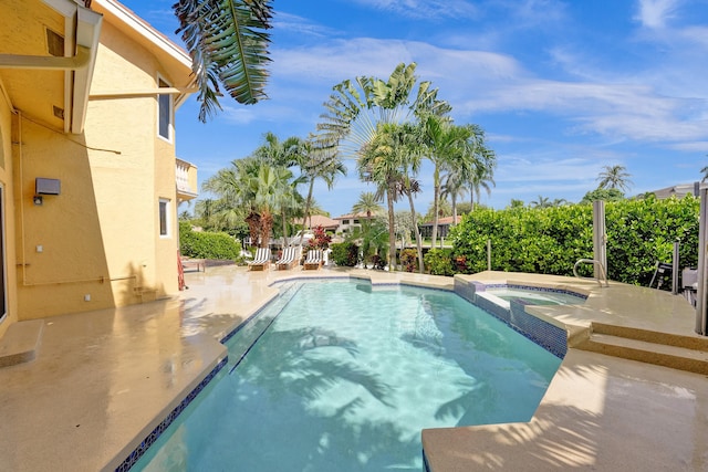 view of swimming pool with a patio and an in ground hot tub