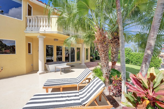 view of patio with an outdoor living space and a balcony